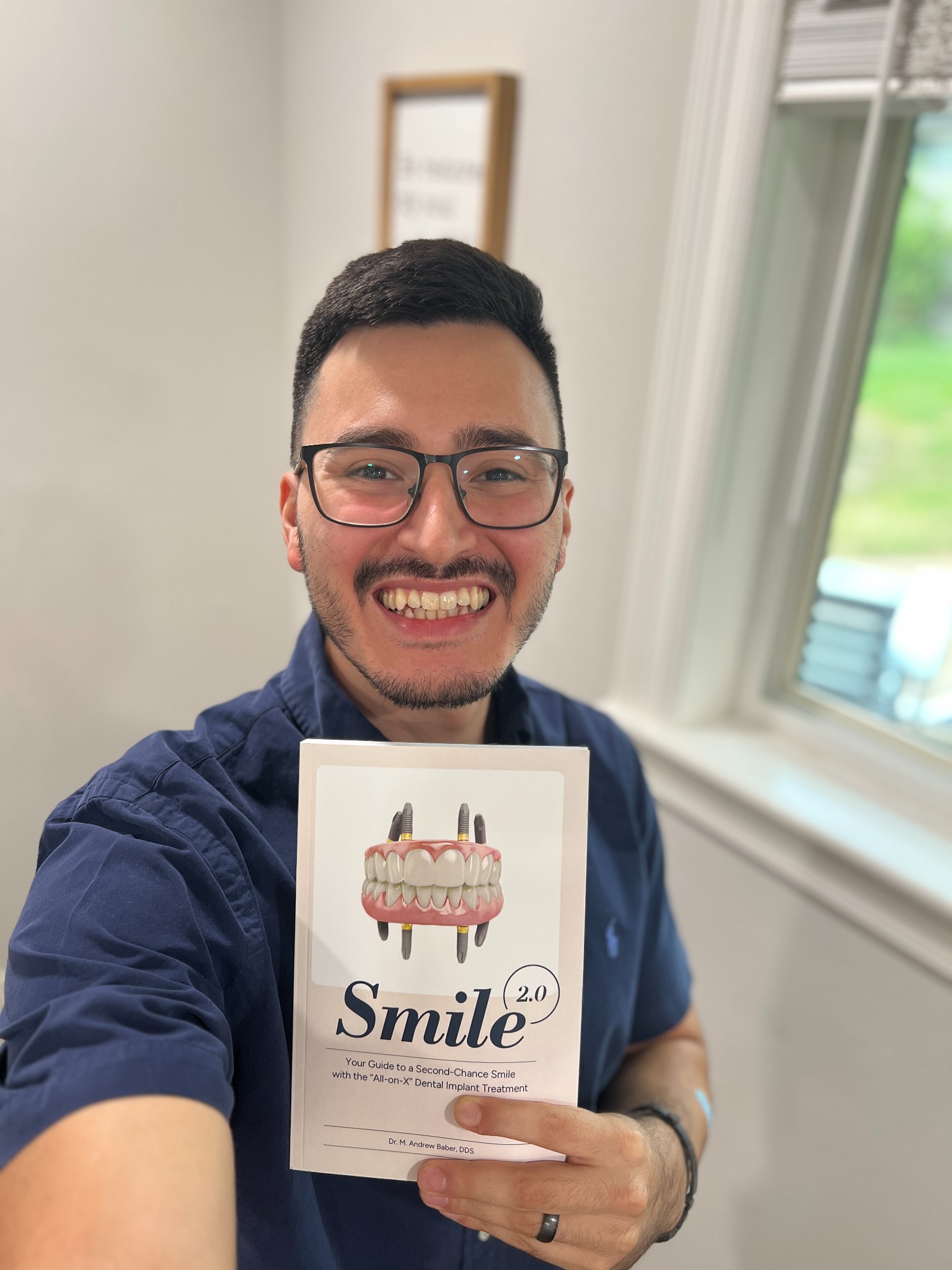 Edgar Sanchez holding a printed copy of Smile 2.0.
